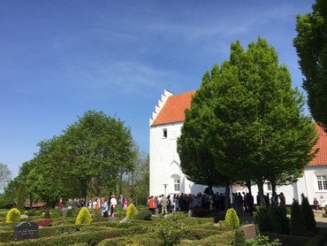 Næsbyhoved Broby kirke udefra med konfirmations gæster rundt om indgangsdøren