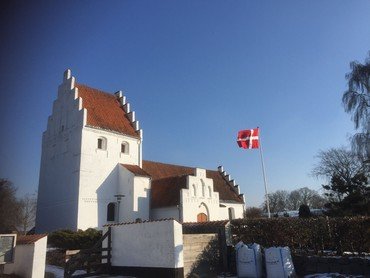 Allesø kirke, blå himmel og flag som står flot vandret i vinden